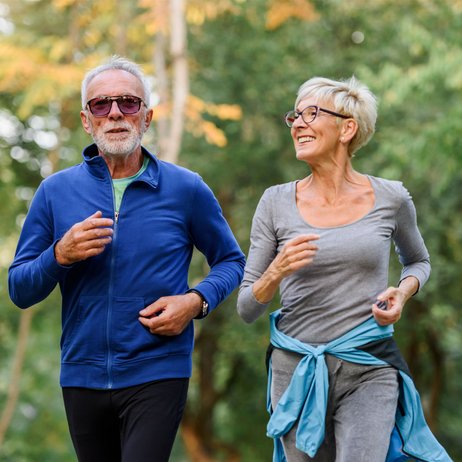 Älteres Ehepaar geht gemeinsam bei schönem Wetter in der Natur joggen
