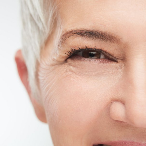 Ältere Frau mit kurzen grauen Haar lächelt mit ihren Augen
